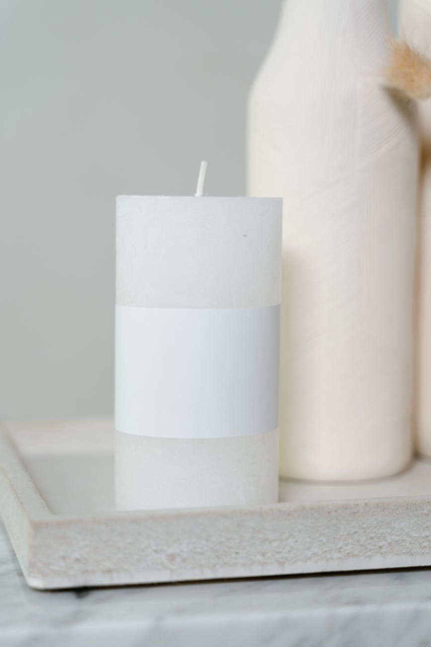 white pillar candle on white tray
