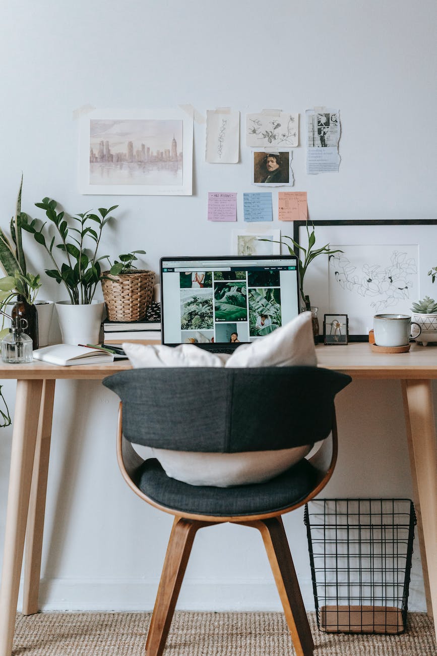 table with laptop and flowerpots in small home office