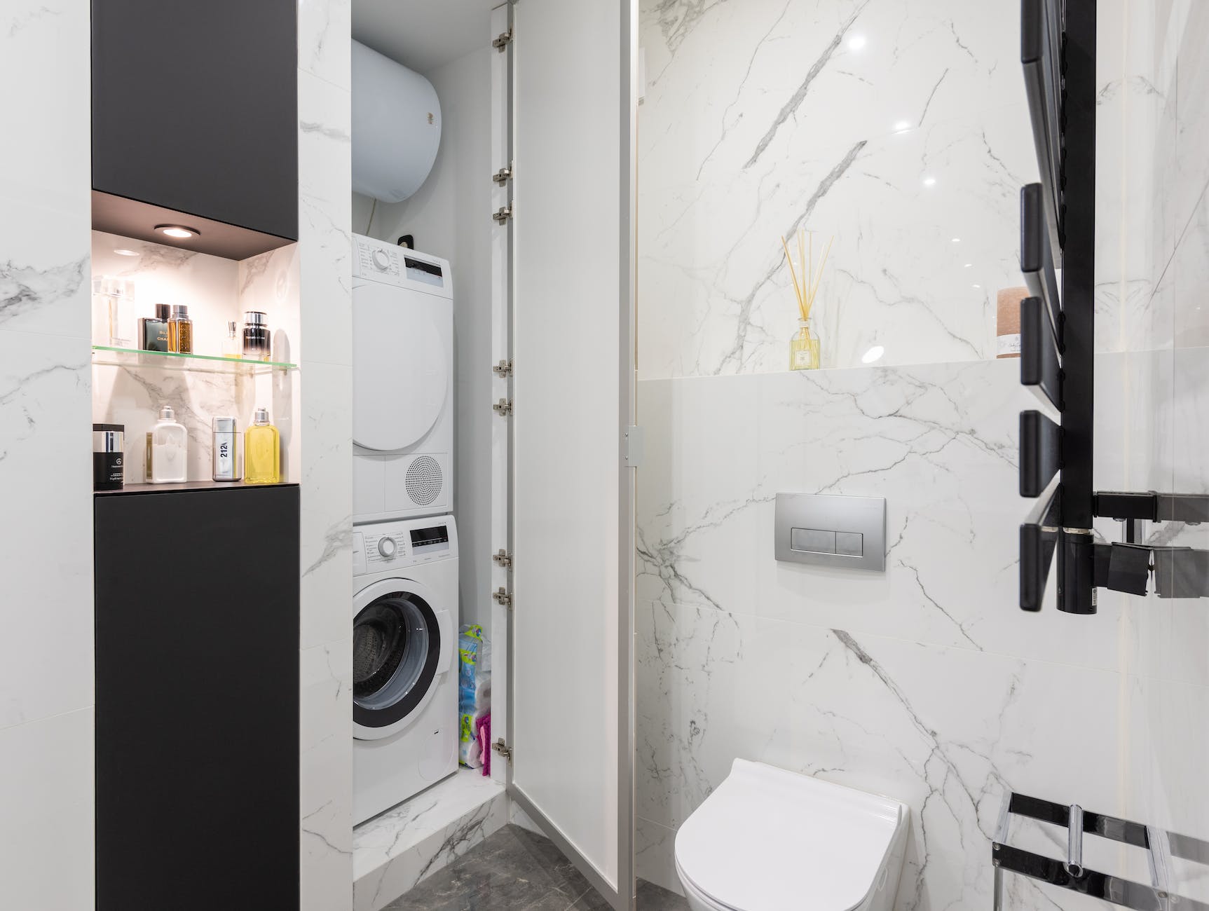 bathroom interior with small laundry closet against toilet bowl